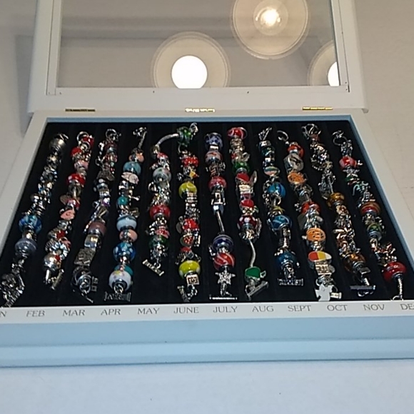 Jewelry - 12 large beads and charms bracelets w/encasement.
